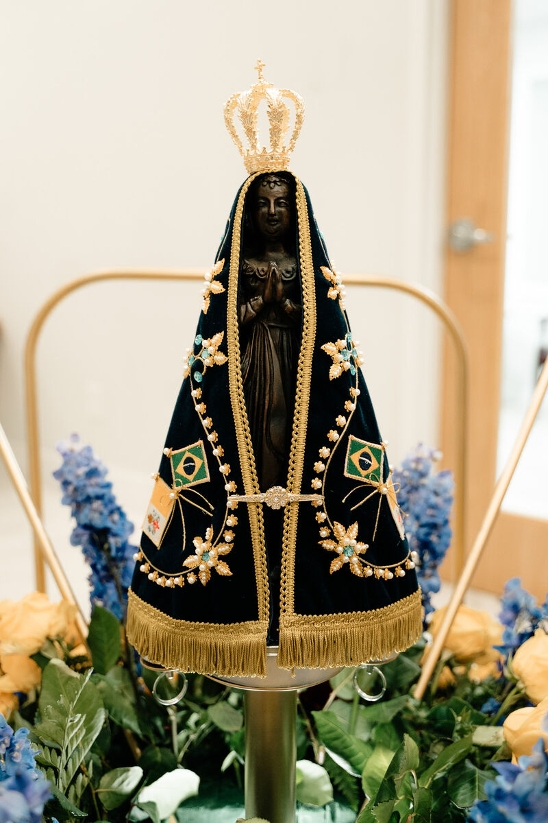 Statue of Nossa Senhora Aparecida, crowned, in a navy and gold mantle