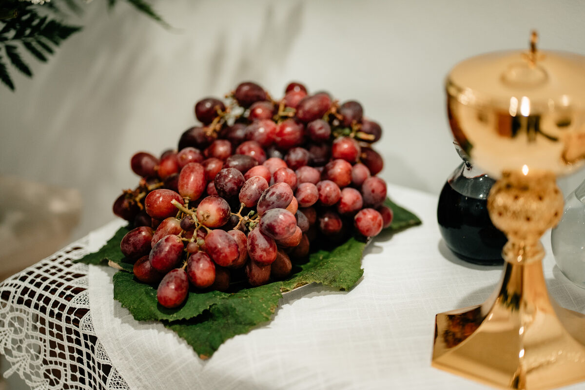 Cluster of red grapes with chalice in the background