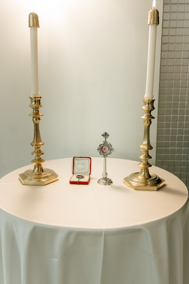 Wedding rings beside candlesticks and a reliquary