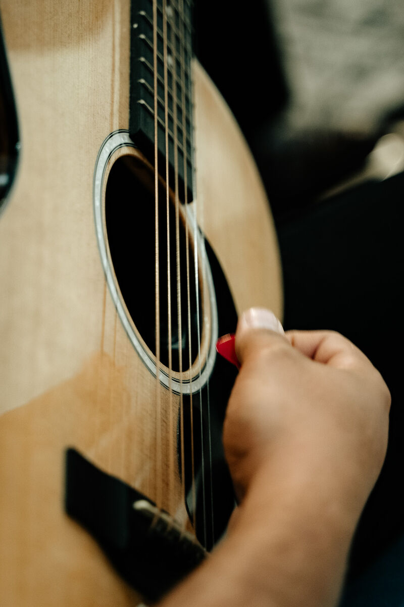 Hand strumming an acoustic guitar in the music ministry