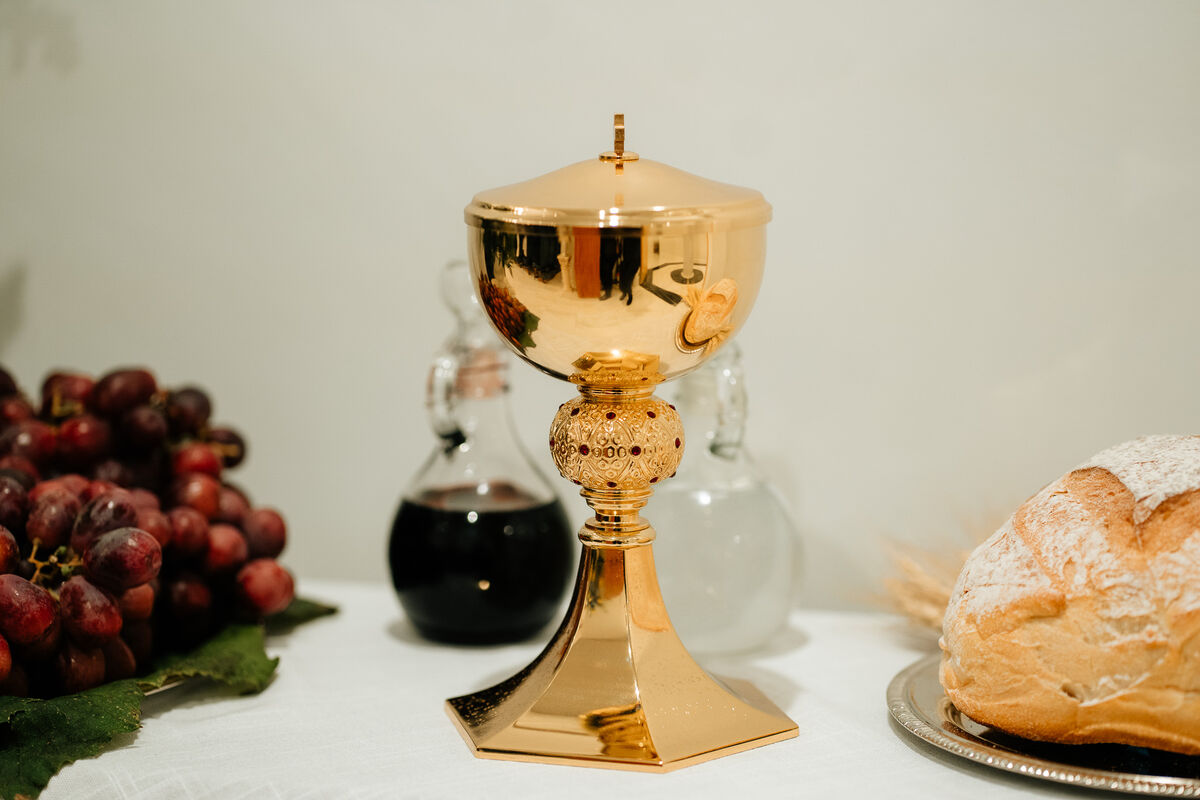 Ornate gold ciborium with grapes and bread