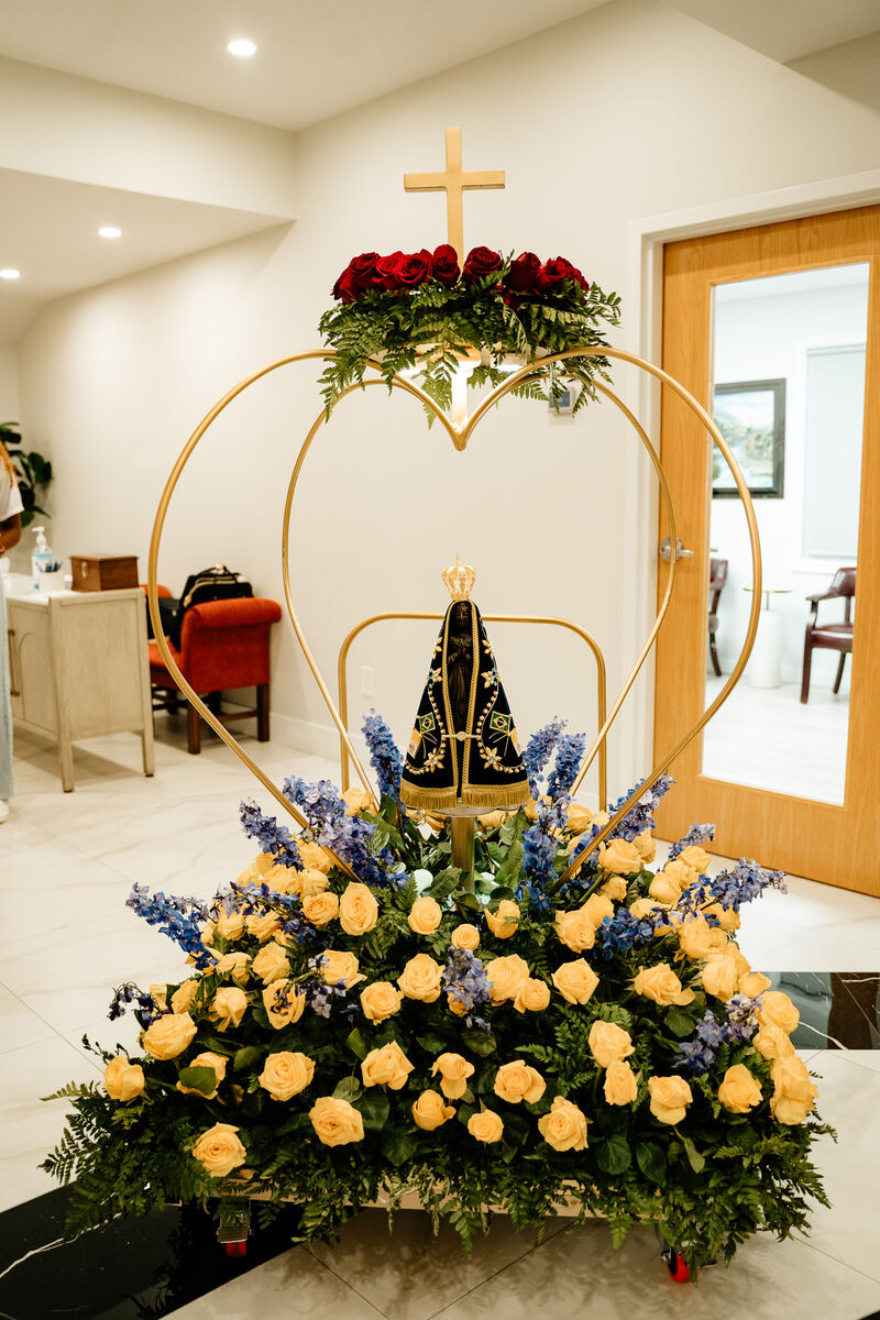 Statue of Our Lady atop a heart-shaped floral arrangement