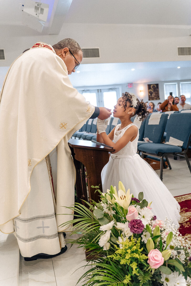 A young girl receives First Holy Communion at Our Lady of Aparecida