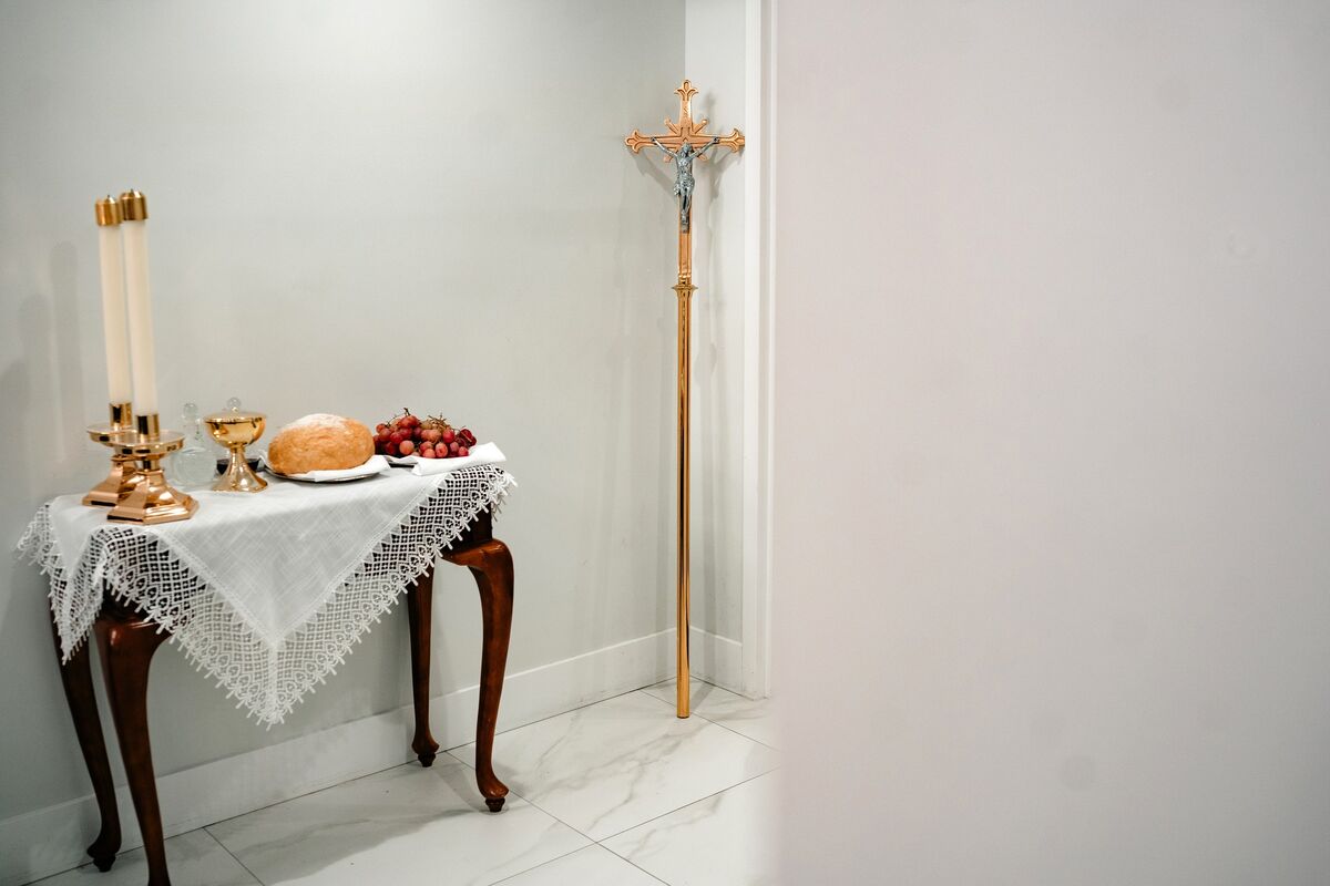 Side table with bread, chalice, candles and the processional cross