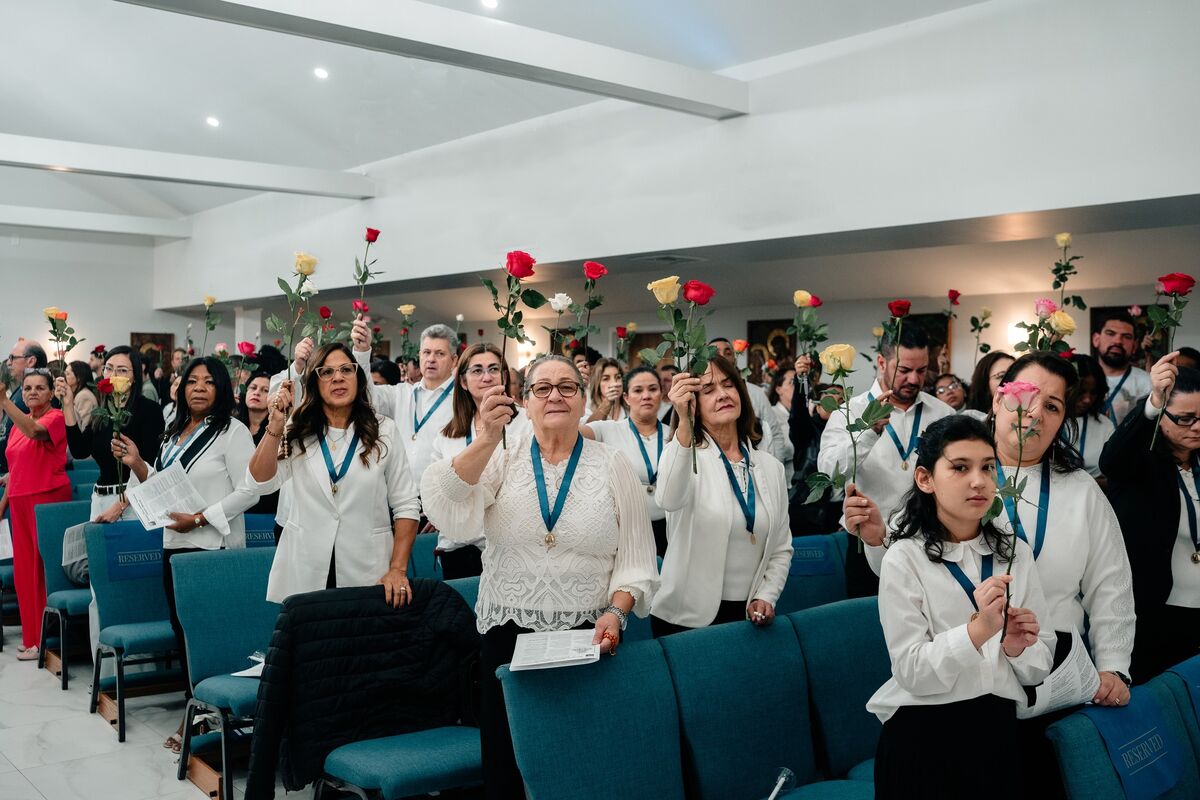 Parishioners raise roses during the May Crowning of Our Lady at Our Lady of Aparecida
